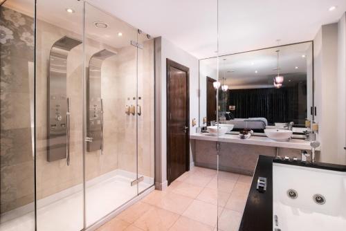 a bathroom with a shower and two sinks and a tub at The Twelve Hotel in Barna