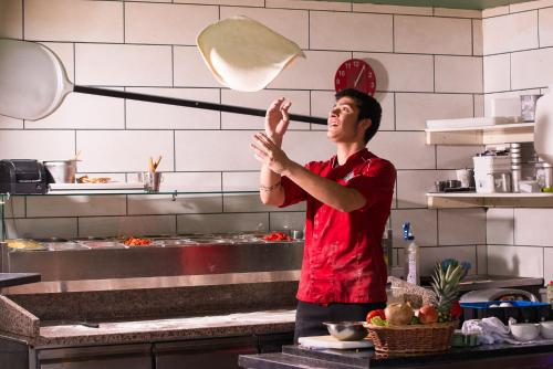 a man in a kitchen tossing a pan at The Twelve Hotel in Barna