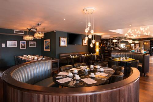 a restaurant with tables and chairs and a bar at The Twelve Hotel in Barna