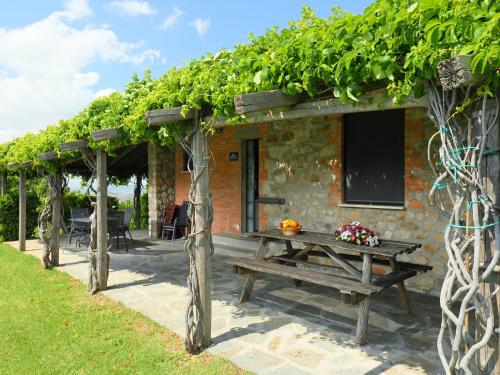 een picknicktafel voor een gebouw met wijnstokken bij Holiday Home Casa dell'Orto by Interhome in Case Bardi