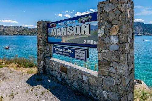 a sign for the welcome to manzanon on a lake at Beaches and Breezes on Wapato - 4 Bed 4 Bath Vacation home in Wapato Point in Manson