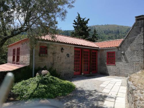a stone house with red doors and red windows at Casa do Silvério in Santa Cruz do Douro