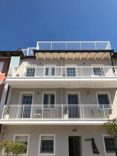 a white building with white balconies on it at Laura e Christian - Rooms in Grado