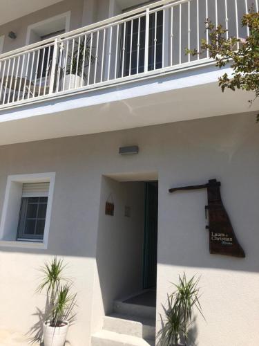 a white house with a staircase and potted plants at Laura e Christian - Rooms in Grado