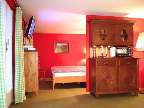 レンクにあるApartment Pony 2-Bettwohnung by Interhomeの赤い壁のベッドルーム1室(ベッド1台、キャビネット付)