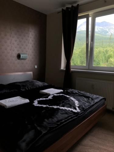 ein Schlafzimmer mit einem Bett vor einem Fenster in der Unterkunft Apartmán pod Gerlachovským štítom in Vysoké Tatry