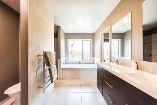 baño con 2 lavabos, bañera y ventana en Rolleston Paradise-Master Bedroom with Ensuite Only, en Rolleston