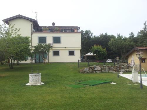 a large white house with a yard with a fountain at Cascina Rosa Camilla in Carpeneto