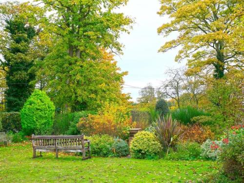a park bench sitting in the middle of a garden at Holiday Home Little Glebe by Interhome in Middleton