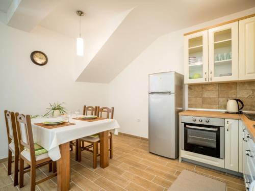 a kitchen with a table and chairs and a refrigerator at Apartment Oltari-3 by Interhome in Biljevine