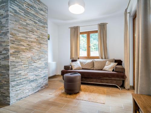 a living room with a couch and a brick wall at Apartment Oltari-1 by Interhome in Biljevine