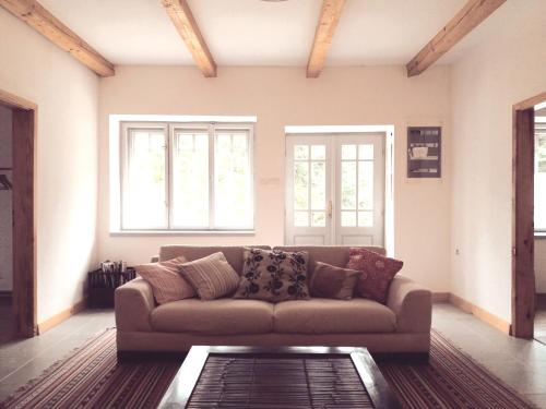 a living room with a couch and two windows at Füveskert in Erdőbénye