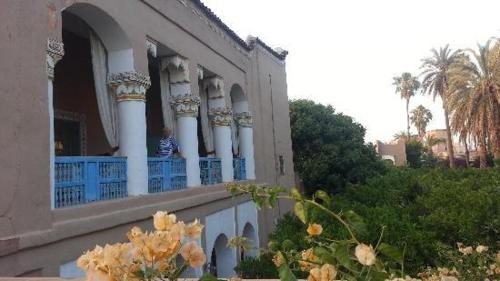 a building with a balcony with blue fence and flowers at Palais Riad Hida in Oulad Berhil