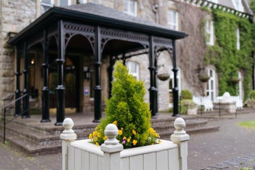 a white fence with a christmas tree in front of a building at Grange Hotel in Grange Over Sands