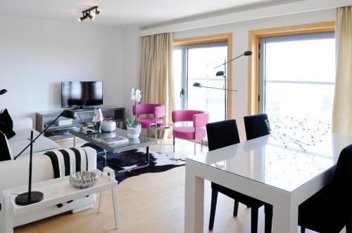 a living room with a white couch and pink chairs at Panoramic Living in Lisbon