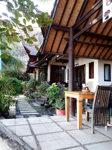 un patio con tavolo e sedie in legno di fronte a un edificio di Bali Villa coral ad Amed