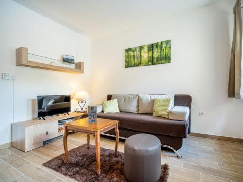 a living room with a couch and a table at Apartment Oltari-3 by Interhome in Biljevine