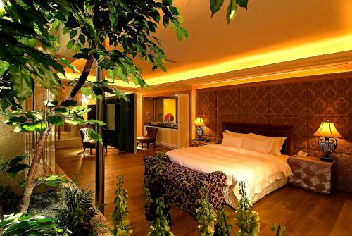 una camera d'albergo con letto e albero di All-Ur Boutique Motel-Ping Tung Branch a Città di Pingtung