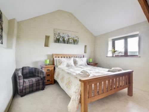 a bedroom with a bed and a chair at Holiday Home Crow by Interhome in Witheridge