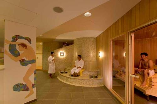 a bathroom with a bath tub with people in it at GenoHotel Karlsruhe in Karlsruhe