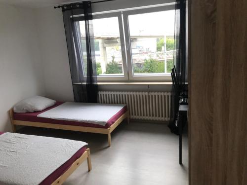 um pequeno quarto com 2 camas e uma janela em andSleep em Mainz
