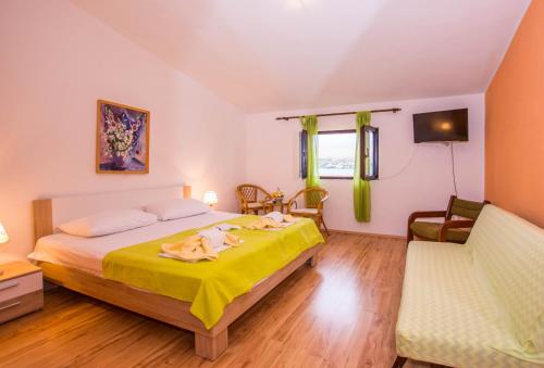 a bedroom with a bed with a yellow blanket on it at House Lanterna Pag in Pag