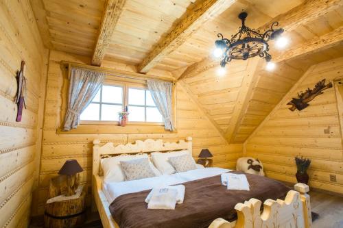 a bedroom with a bed in a log cabin at Zbojnicky penzion in Oravska Jasenica