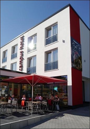 a building with tables and chairs in front of it at Campushotel in Hagen