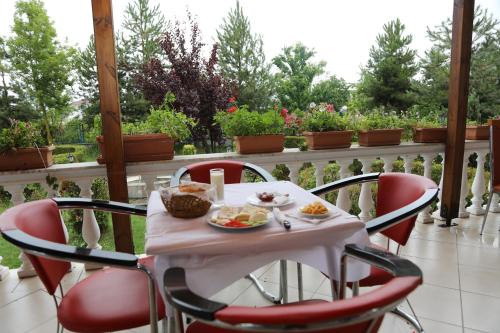a table with red chairs and food on a patio at Hotel Villa Kabashi in Korçë