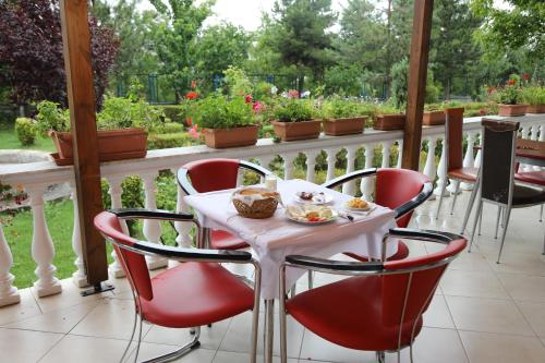 a table and chairs on a porch with a view of a garden at Hotel Villa Kabashi in Korçë