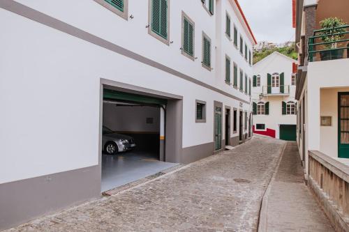 an alley in a building with a car garage at Vila Mar Apartment in Ponta do Sol
