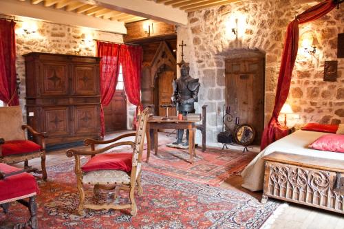 a bedroom with a bed and a desk in it at Château de Chantelauze in Olliergues