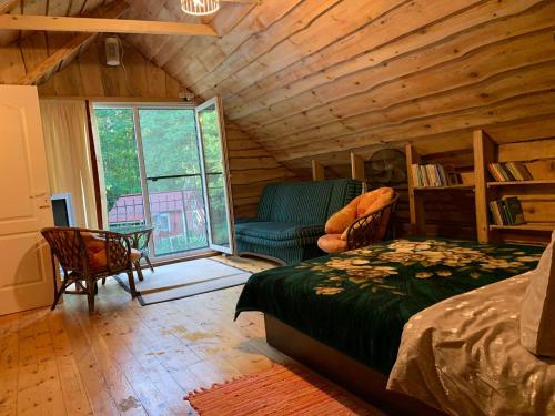 a bedroom with a bed and a couch and a table at Adeles sodyba in Sturmai