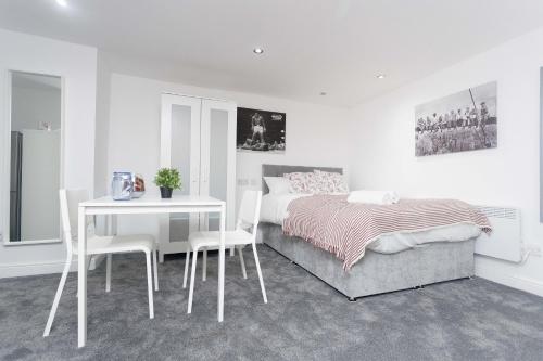 1 dormitorio con 1 cama, mesa y sillas en Leeds House, en Leeds