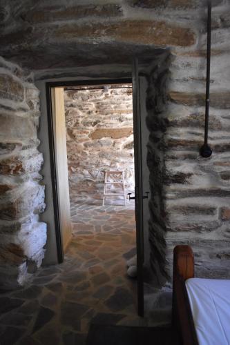 a doorway to a room with a stone wall at Private Home 2' from the beach, Orkos Kea in Orkos