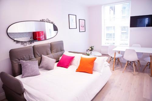 a bedroom with a large bed with colorful pillows at Quiet Central West End Apartments by Indigo Flats in London