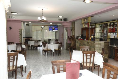 a dining room with tables and chairs in a restaurant at Hotel Villa Kabashi in Korçë