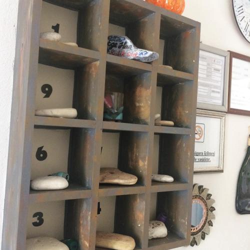 a wooden shelf with different types of objects on it at Ege Han Hotel in Bozcaada