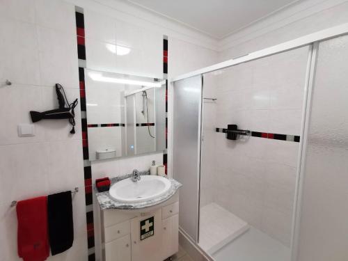 y baño blanco con lavabo y ducha. en Apartamento Praia Rocha Vista Mar Ambar en Portimão