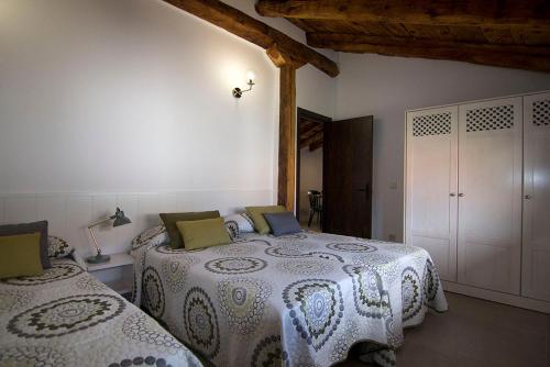 Un dormitorio con dos camas en una habitación. en Casa Barrena, en Albarracín