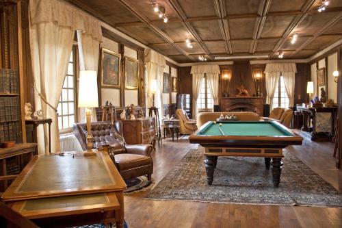 un salon avec une table de billard dans l'établissement Château de Chantelauze, à Olliergues