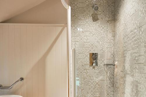 a shower with a glass door in a bathroom at The Lister Arms in Malham