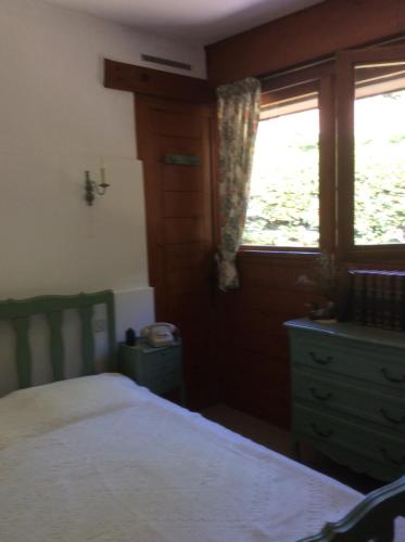 um quarto com uma cama, uma cómoda e uma janela em Chez Uli em Angresse
