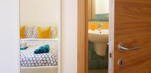 La salle de bains est pourvue de toilettes et d'un lavabo avec des chaussures bleues. dans l'établissement Acqua Chiara, à Alghero