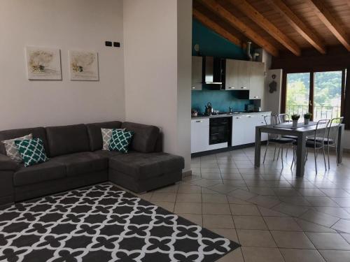 Appartamento El Cio في Vobarno: غرفة معيشة مع أريكة وطاولة ومطبخ