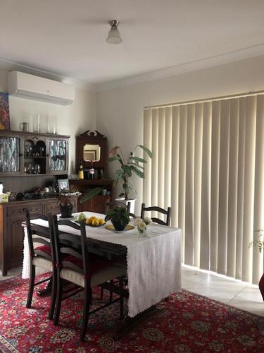 a dining room with a table and chairs and a window at Not quite the Ritz in West Richmond