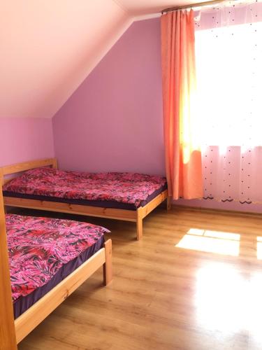 two beds in a room with a window at MKA Life in Ventspils