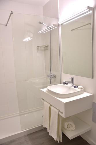 a white bathroom with a sink and a shower at Hotel Sol Algarve by Kavia in Faro
