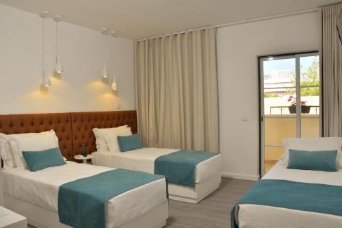 a hotel room with two beds and a window at Hotel Sol Algarve by Kavia in Faro