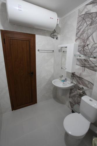 a bathroom with a toilet and a sink and a light at Villa Salena in Primorsko